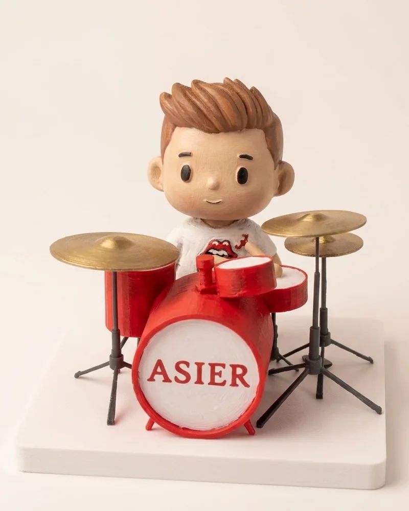 Ninotet tocant una bateria vermella amb el nom Asier